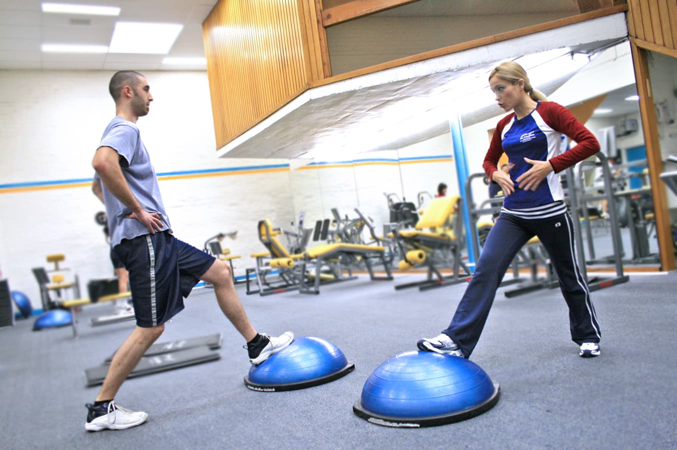 Personal trainer coaching a member through an exercise